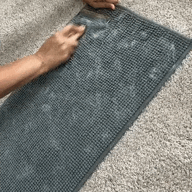 a women using pet hair remover for carpet that is called fursweep