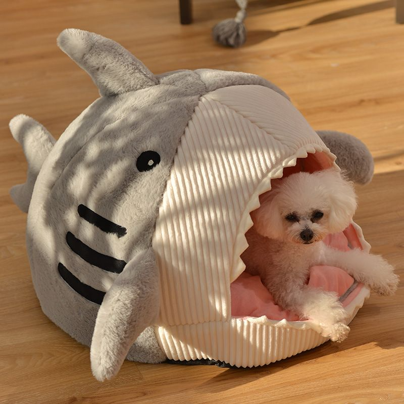 a shark shaped dog bed with a dog inside